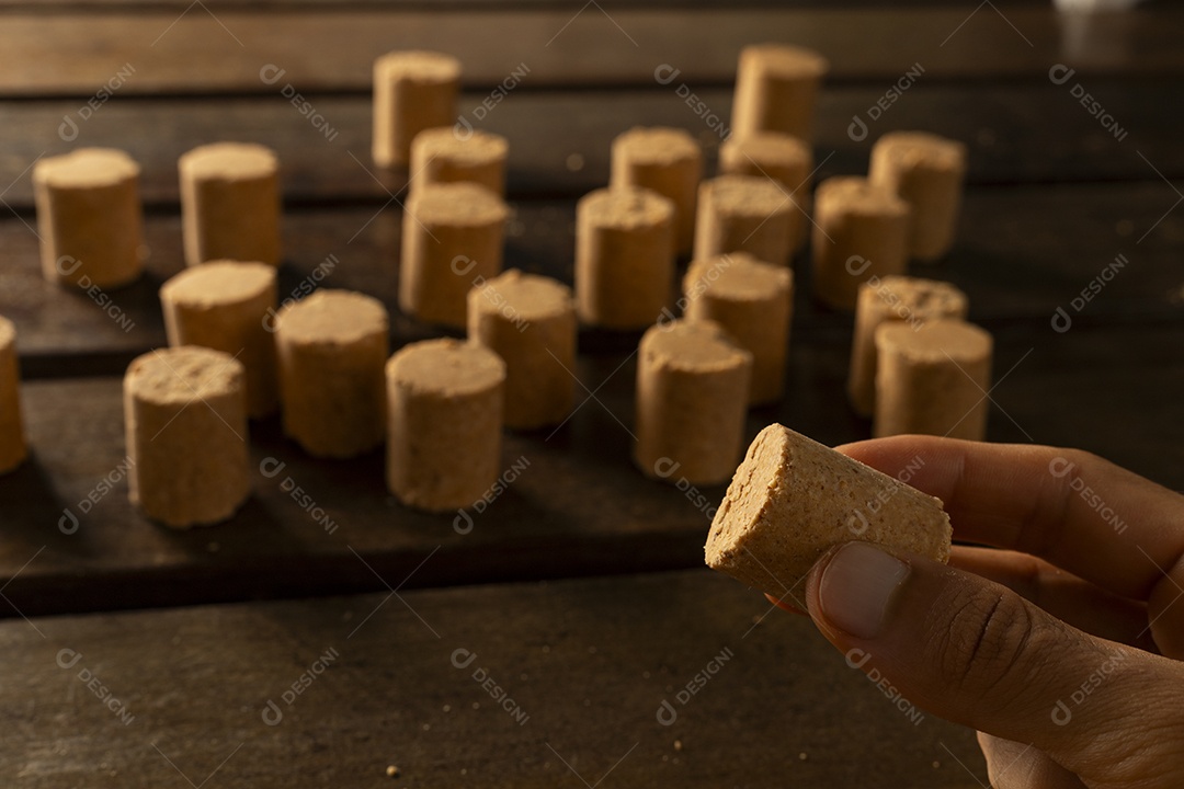 Paçoca deliciosa na mesa e mão segurando outra