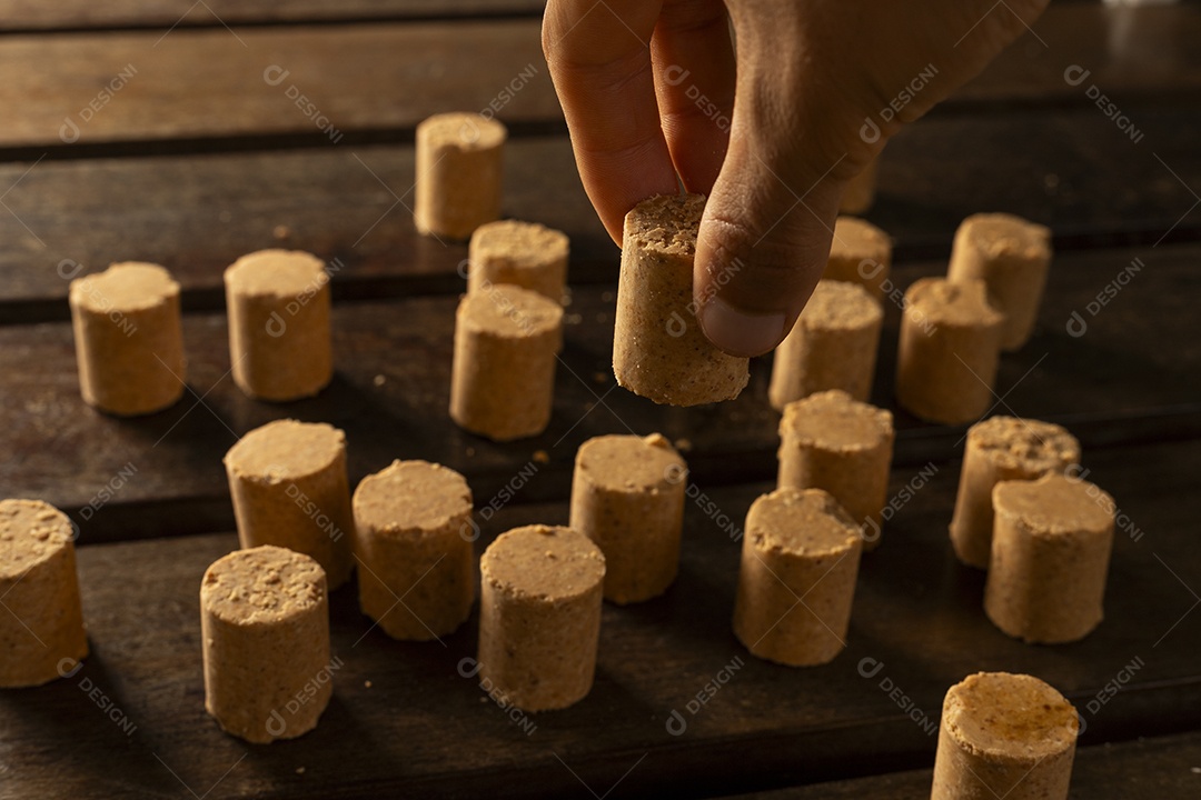 Mão pegando paçoca nna mesa