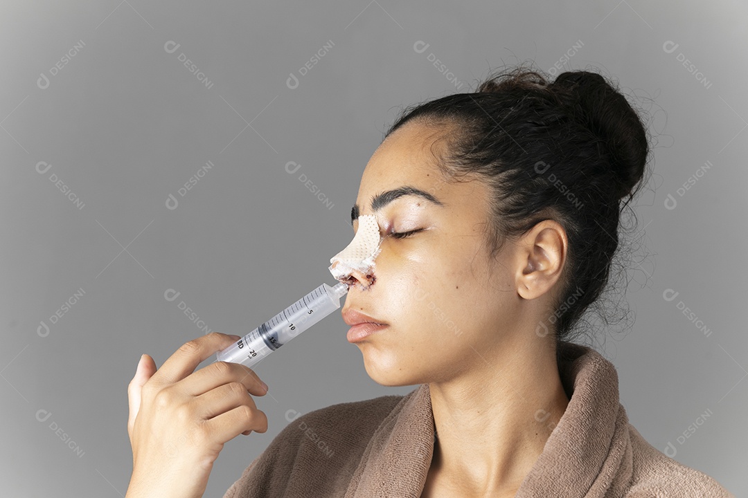 Mulher com nariz enfaixado e seringa no nariz