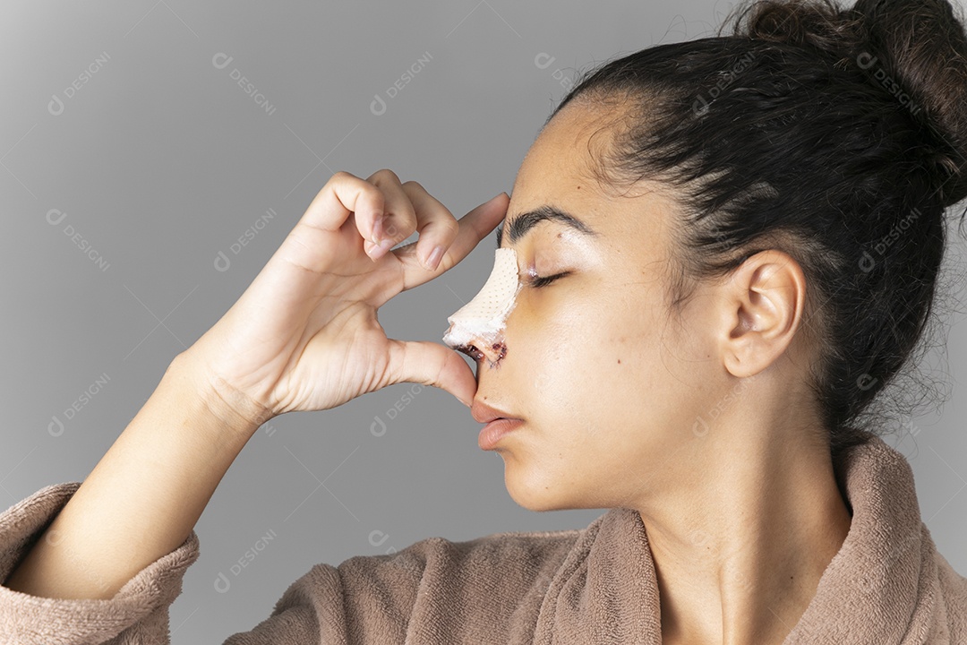 Mulher com mãos no nariz mostrando cirurgia