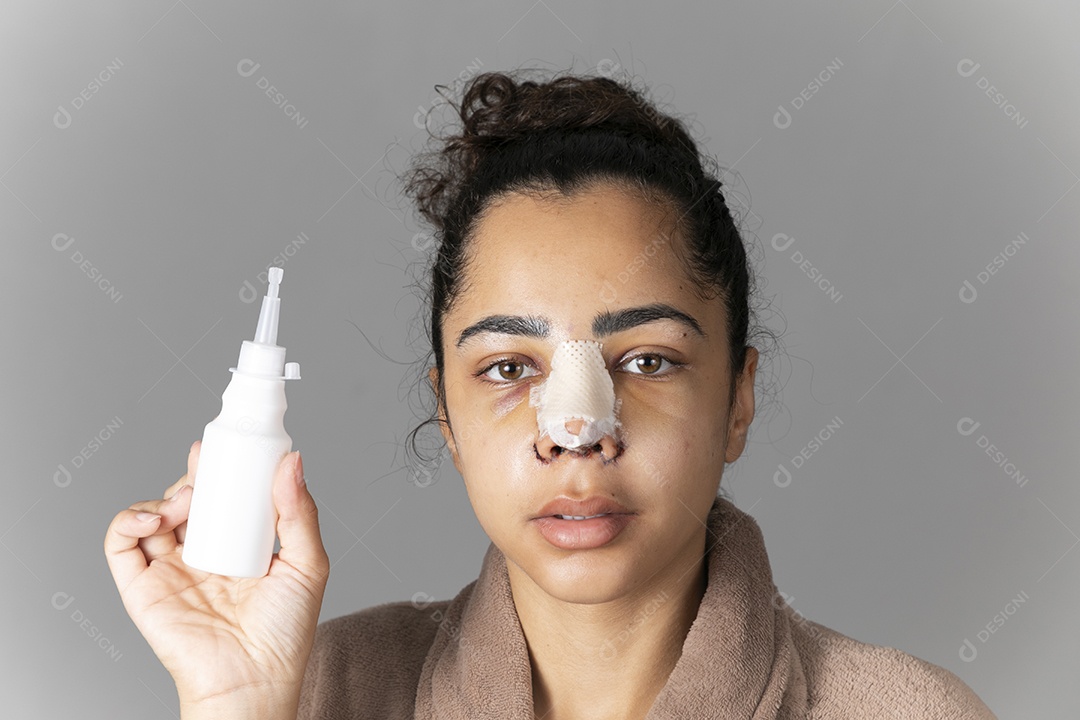 Mulher com cirurgia no nariz segurando um vidro de remédio