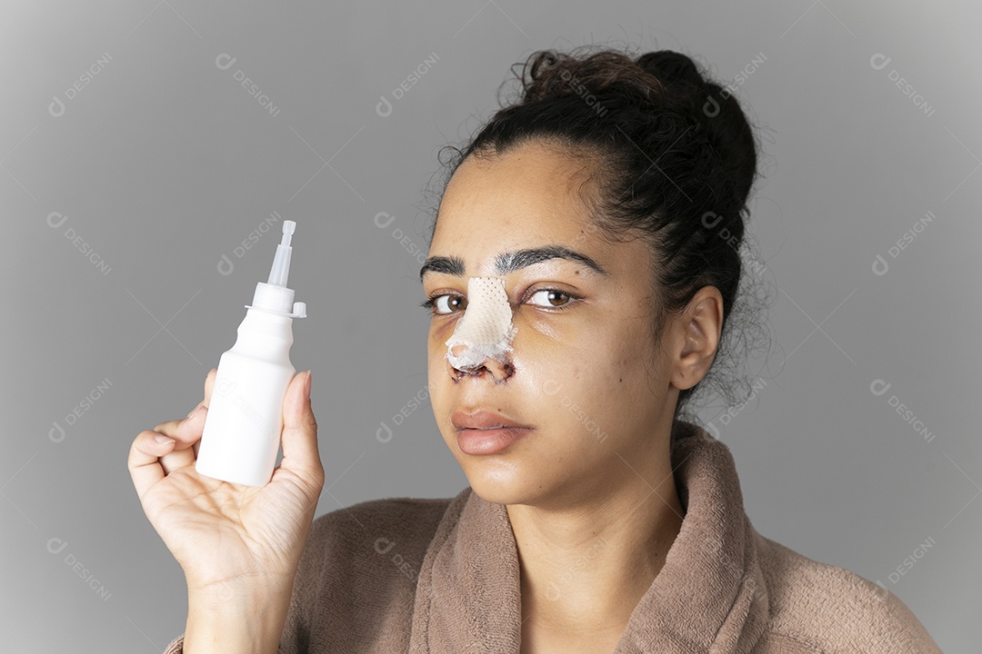 Mulher olhando de lado e segurando vidro de remédio na mão