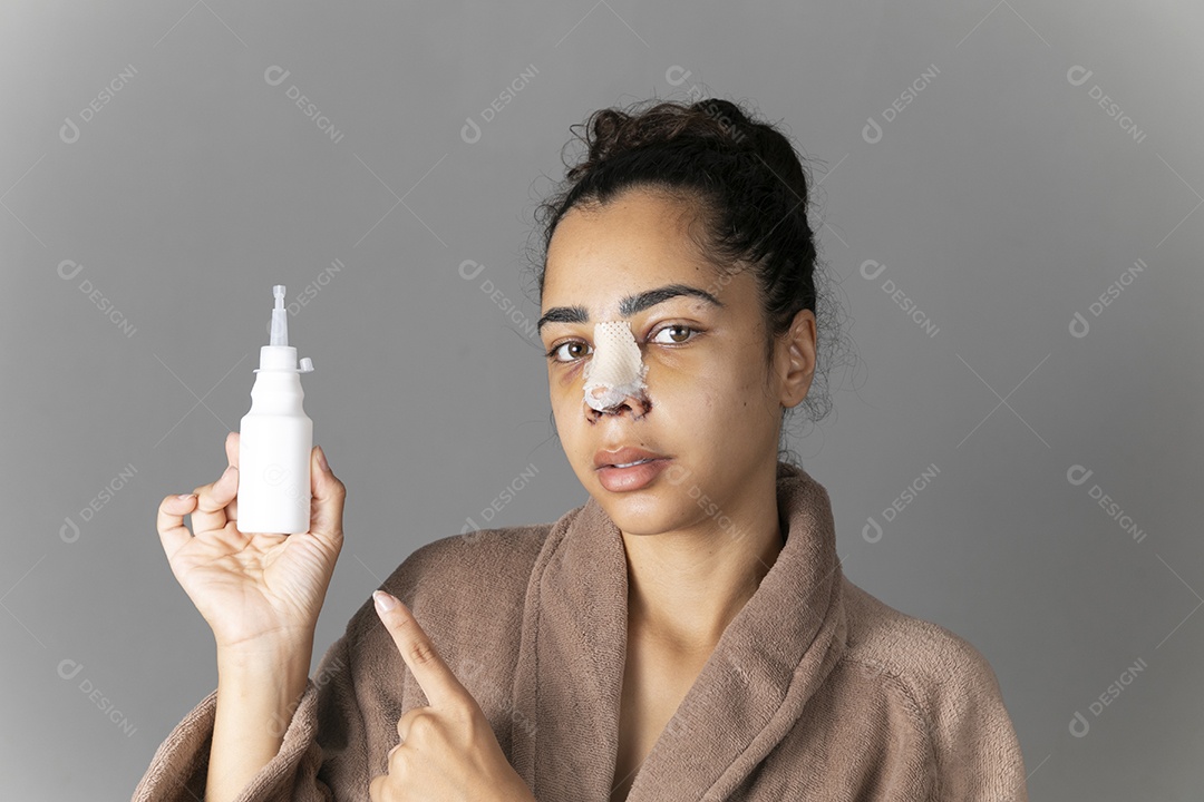 Mulher com remédio ns mãos e nariz enfaixado