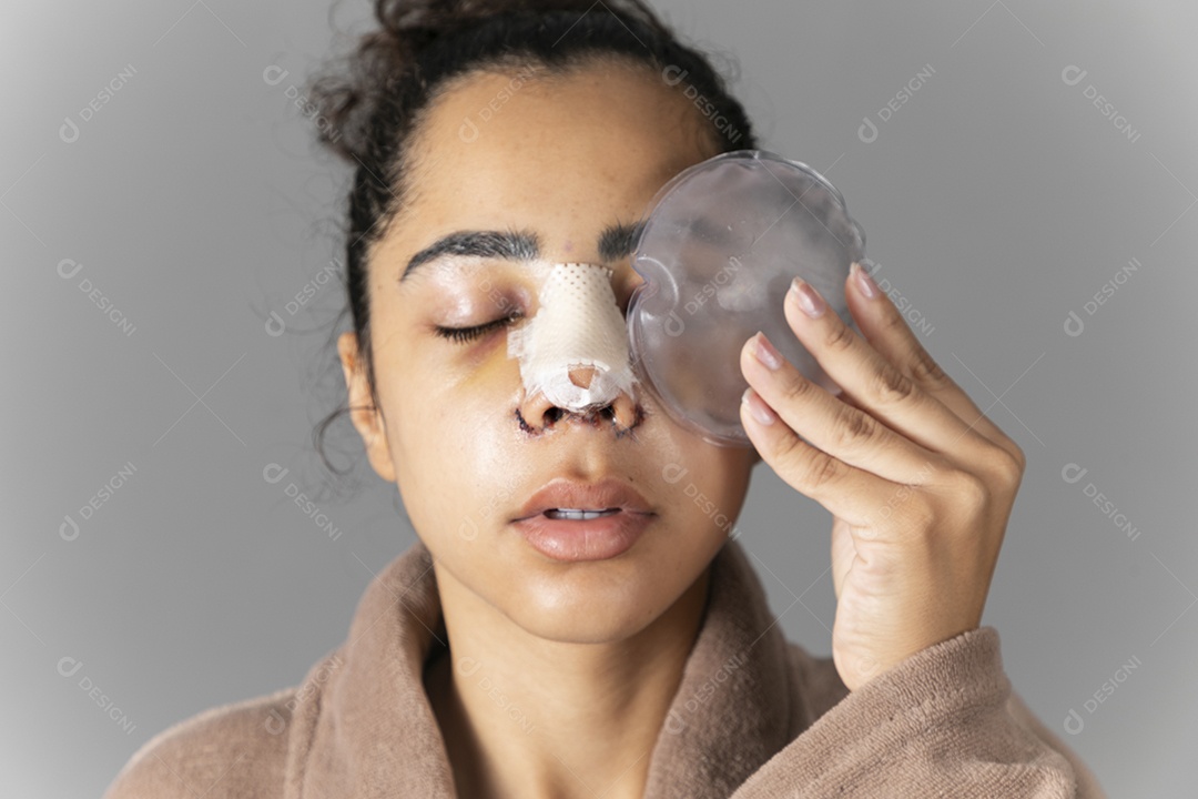 Mulher segurando bolsa de gelo no rosto