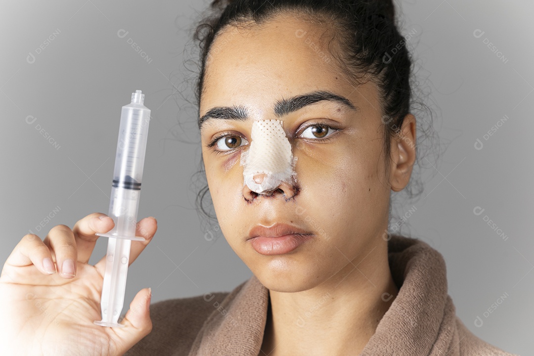 Mulher com nariz enfaixado e seringa na mão
