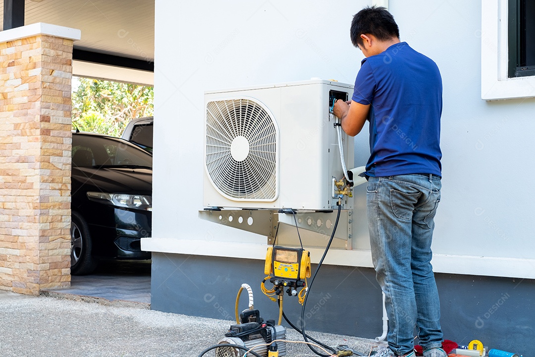 Técnico masculino instalando unidade externa de ar condicionado para resfriar a casa no verão