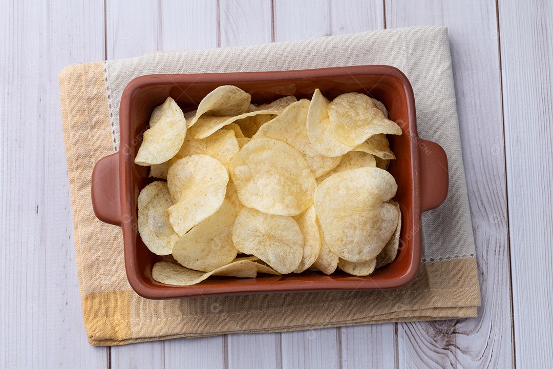 Batatas fritas em um prato sobre a mesa de madeira