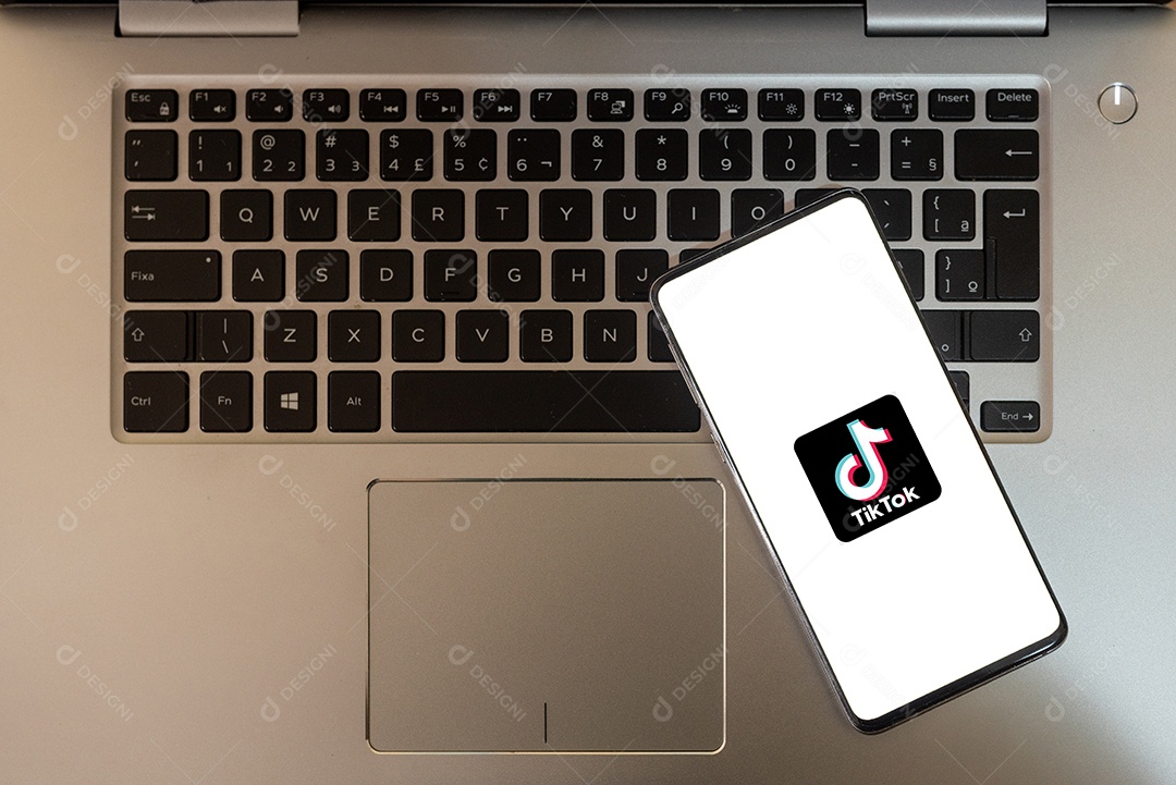 Aplicativo na tela do celular tiktok sobre teclado de notebook