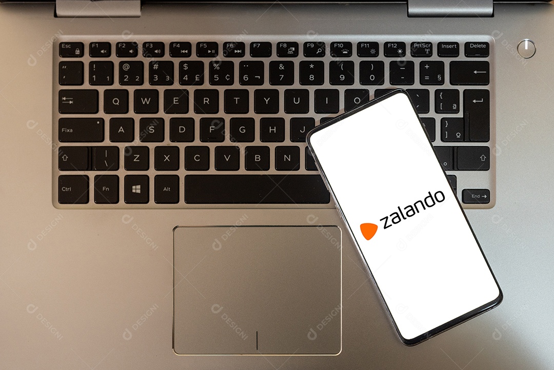 Tela de celular com apliativo zalando sobre teclado de um laptop