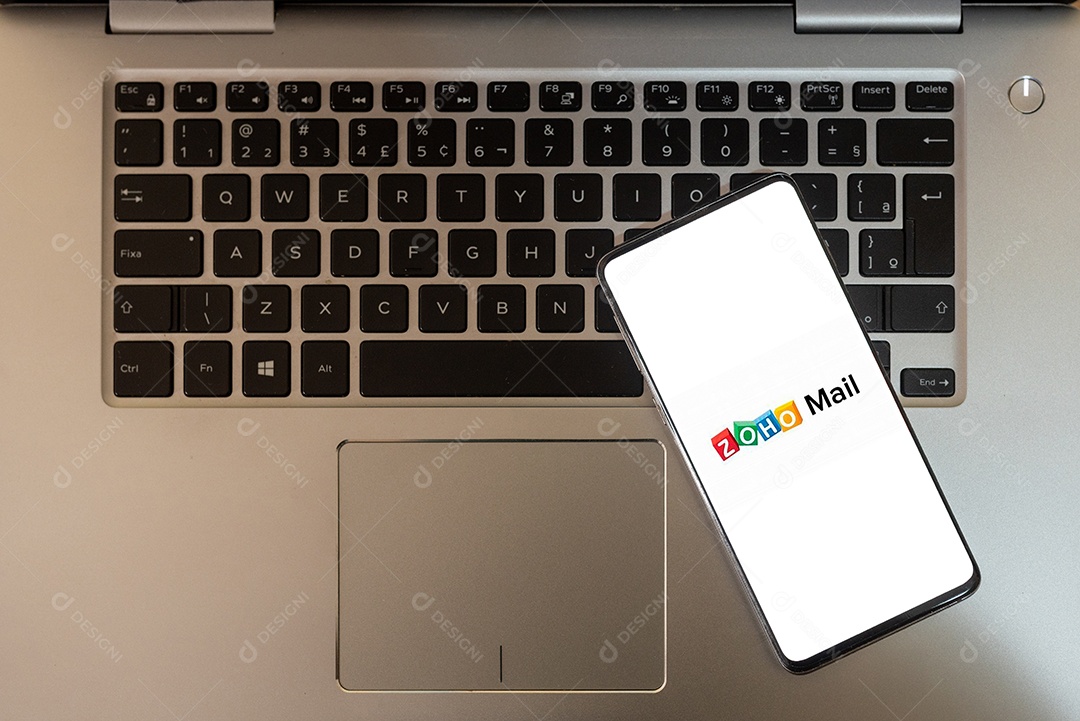 tela de celular com ZOHO mail sobre um teclado de notebook