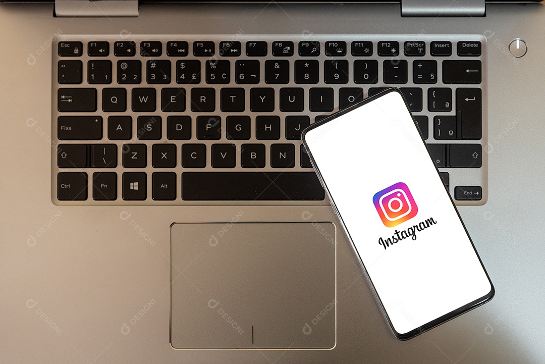 Instagram em tela de celular sobre um teclado de laptop