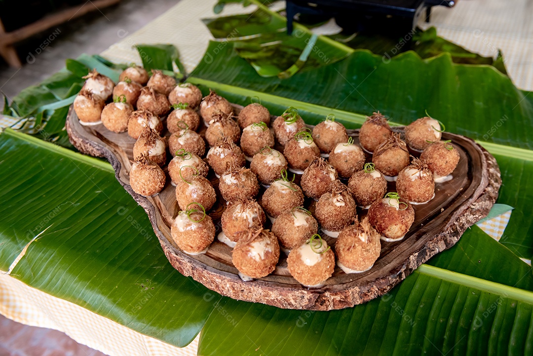 Cozinha rústica bolinhos de peixe em tábua de madeira e folha de bananeira