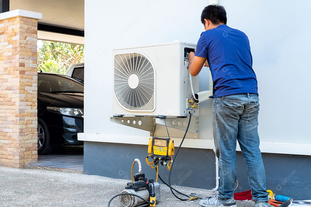 Técnico masculino instalando unidade externa de ar condicionado para resfriar a casa no verão