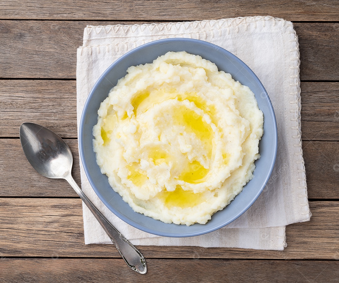 Purê de batata com azeite em um prato sobre a mesa de madeira