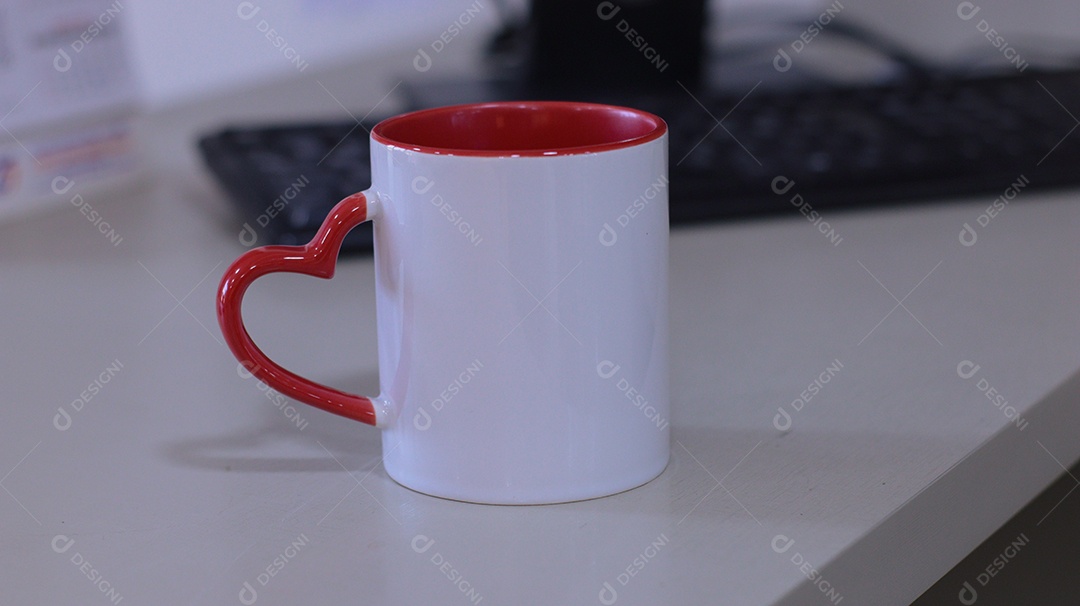 Caneca branca formato de coração sobre uma mesa branca