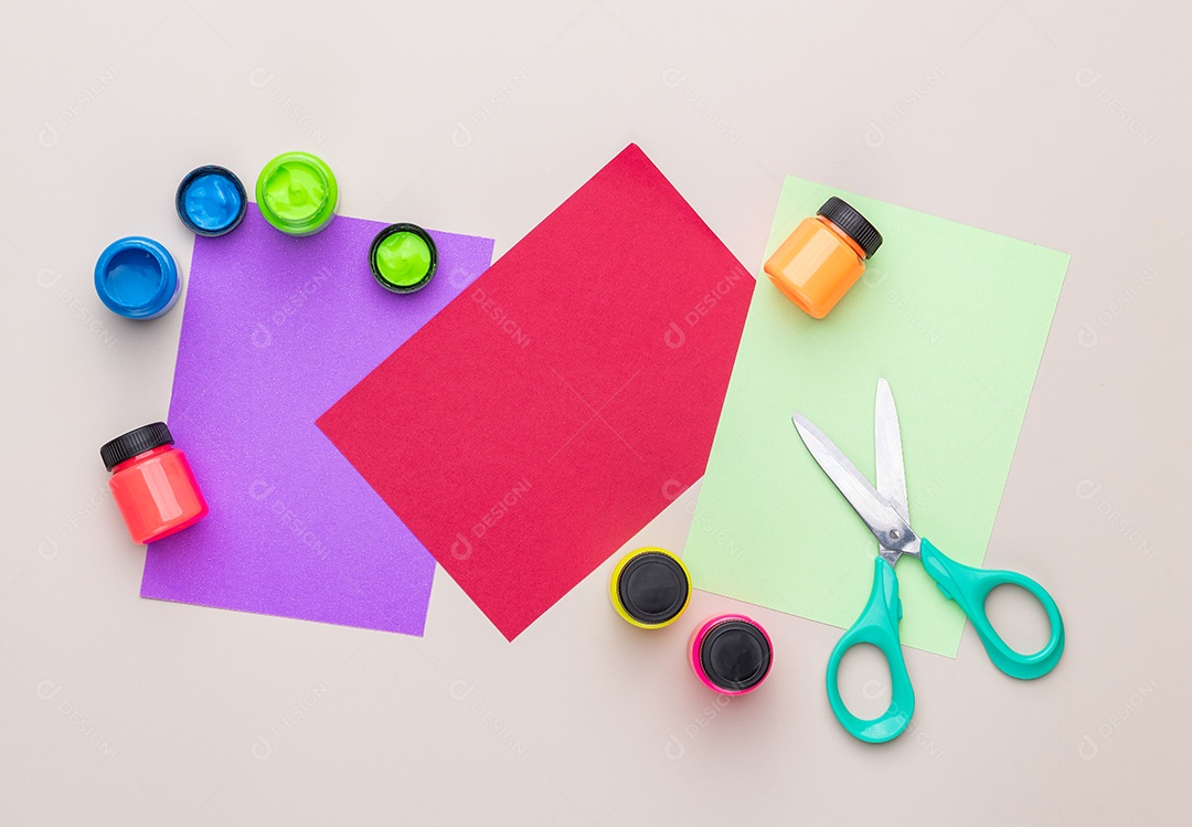 Tinta papel e material escolar sobre fundo marrom claro