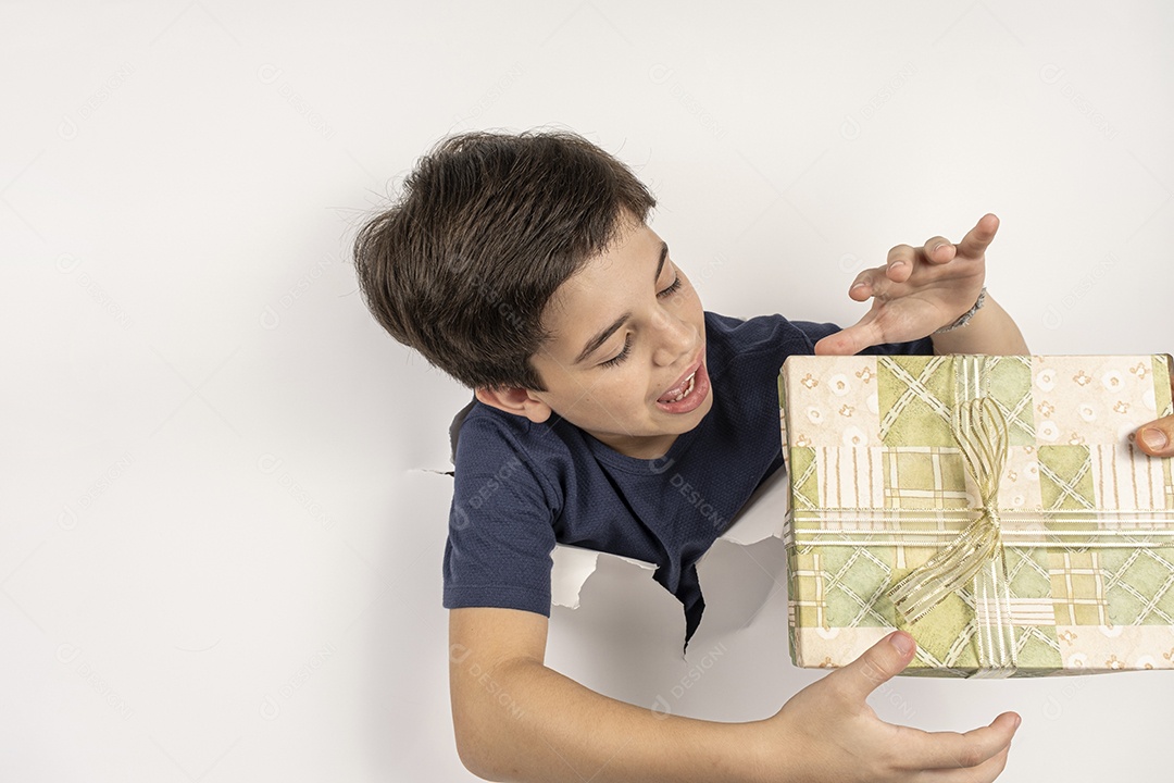 Criança brasileira com o corpo atravessado em uma cartolina branca e o presente na cabeça