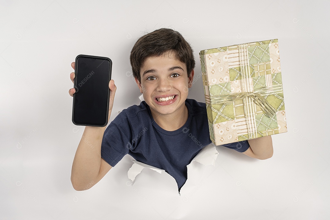 Feliz criança de 11 anos com corpo através de papelão apontando para smartphone