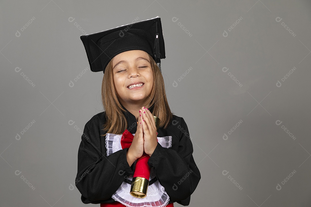 Linda menina com mãos dadas e usando beca de formatura