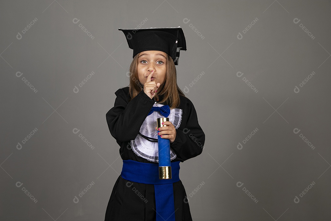 Linda menina usando beca e fazendo gesto de silêncio