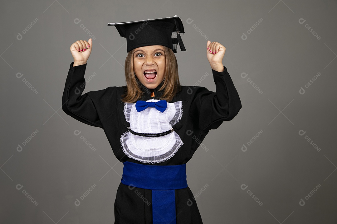 Menina engraçada com gesto de brava e roupa de formatura