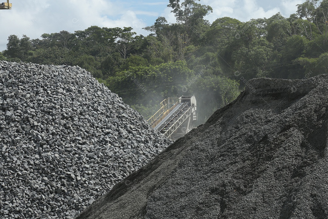 Monte de britas e um britador para serviço