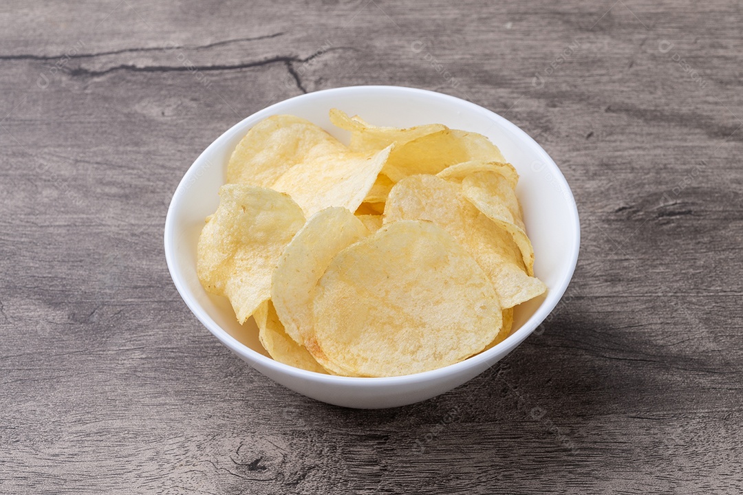 Batatas fritas em um prato sobre a mesa de madeira