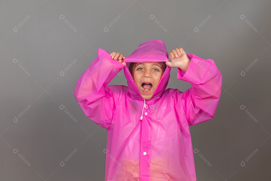 Linda menina usando capa rosa sobre fundo isolado