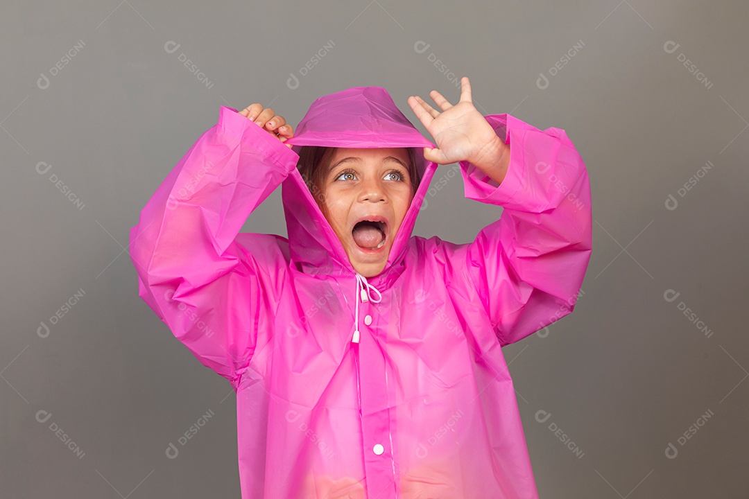 Linda menina usando capa rosa sobre fundo isolado