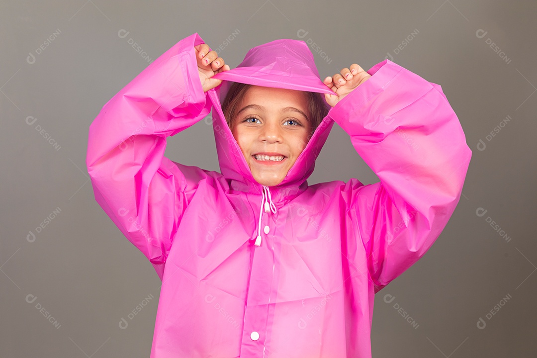 Linda menina usando capa rosa sobre fundo isolado