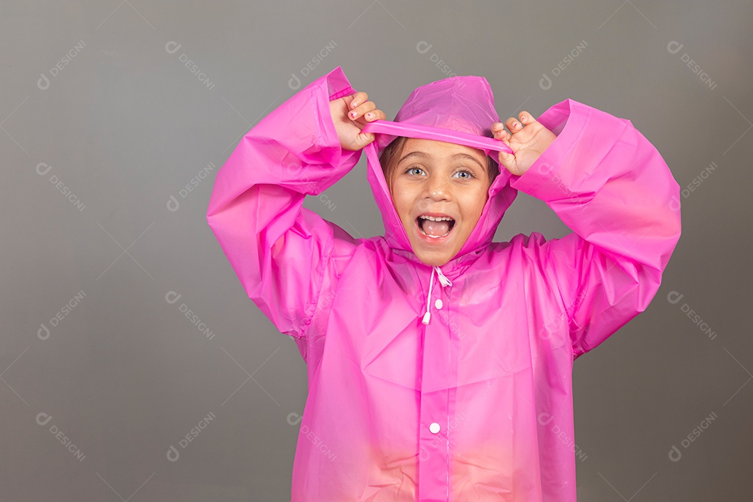 Linda menina usando capa rosa sobre fundo isolado