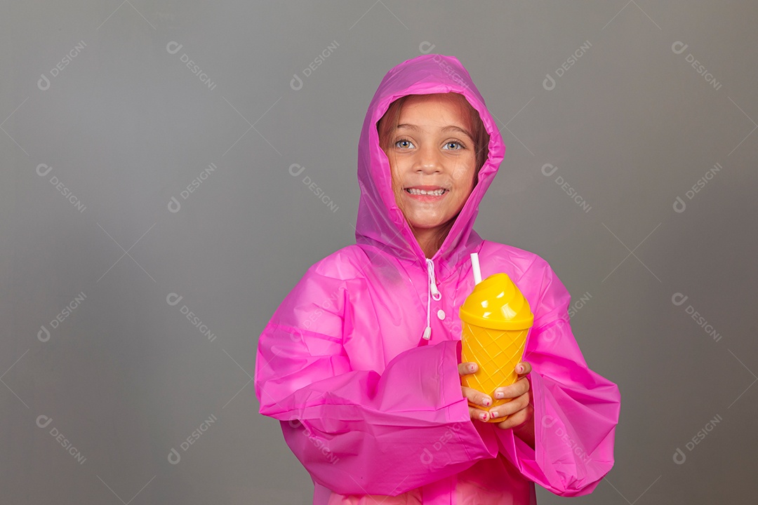 Linda menina usando capa rosa sobre fundo isolado