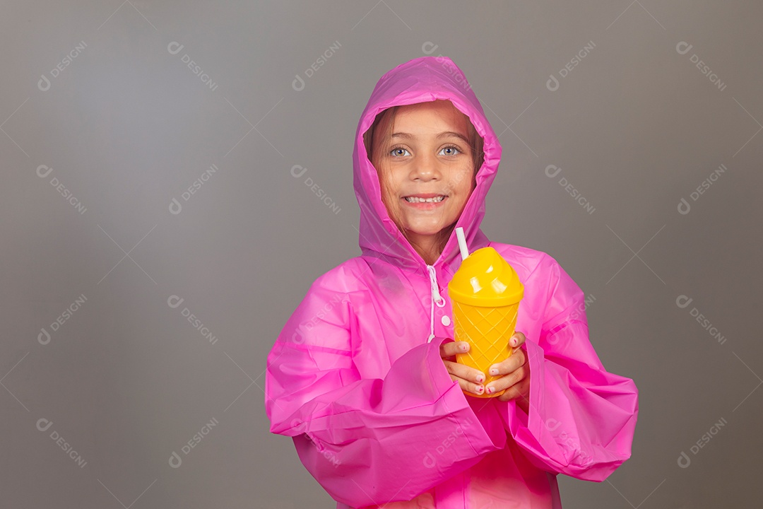 Linda menina usando capa rosa sobre fundo isolado