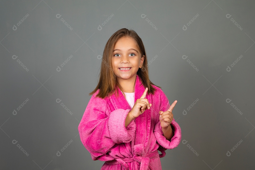 Linda menina usando roupão de banho rosa sobre fundo isolado