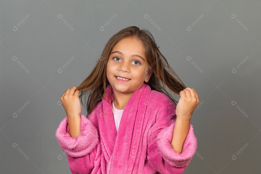 Linda menina usando roupão de banho rosa sobre fundo isolado