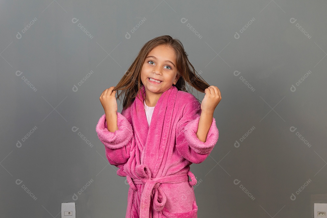Linda menina usando roupão de banho rosa sobre fundo isolado