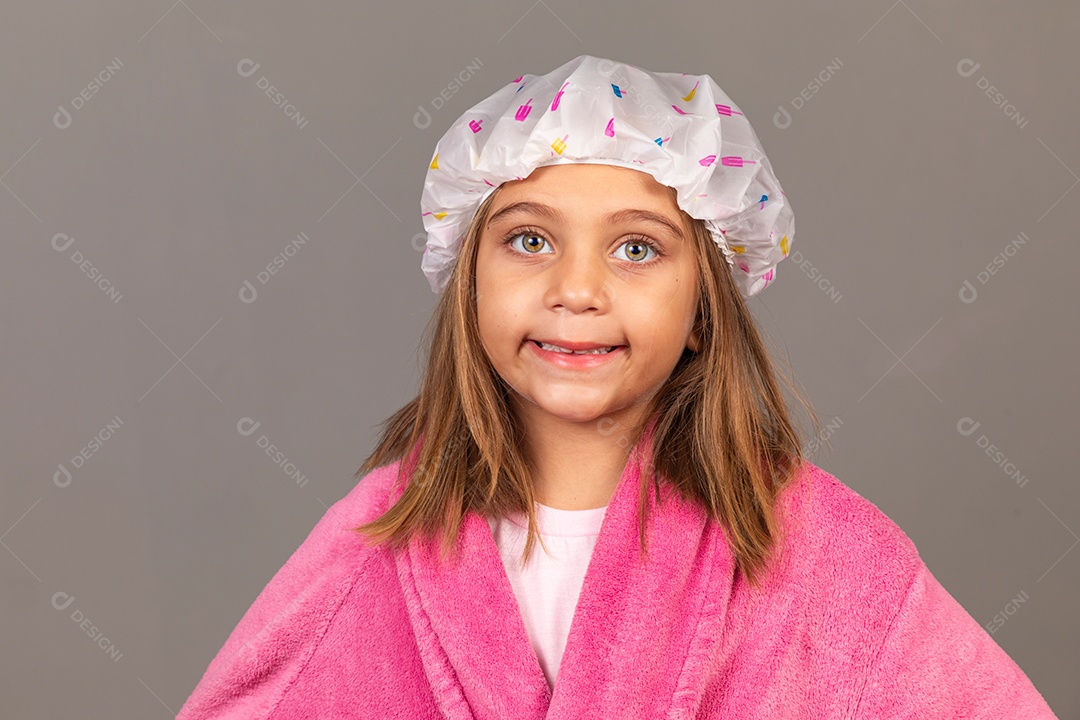 Linda menina usando roupão de banho rosa touca sobre fundo isolado