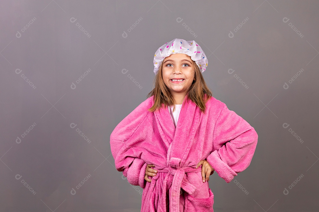 Linda menina usando roupão de banho rosa touca sobre fundo isolado