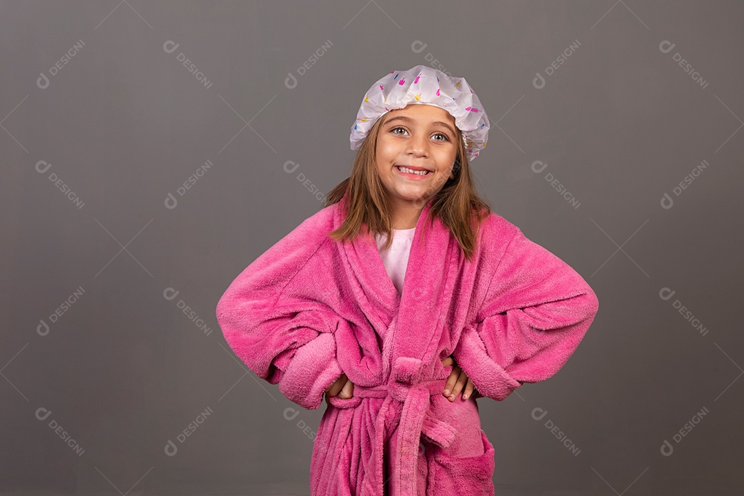 Linda menina usando roupão de banho rosa touca sobre fundo isolado