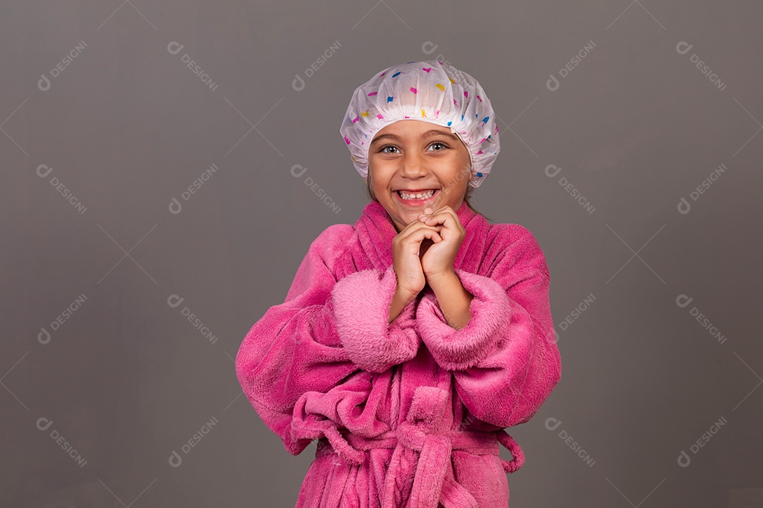 Linda menina usando roupão de banho rosa touca sobre fundo isolado