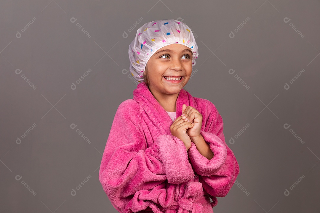 Linda menina usando roupão de banho rosa touca sobre fundo isolado