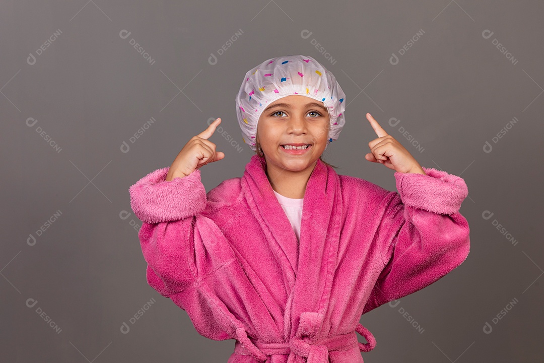 Linda menina usando roupão de banho rosa touca sobre fundo isolado