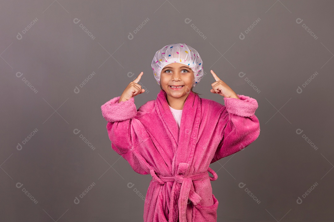 Linda menina usando roupão de banho rosa touca sobre fundo isolado