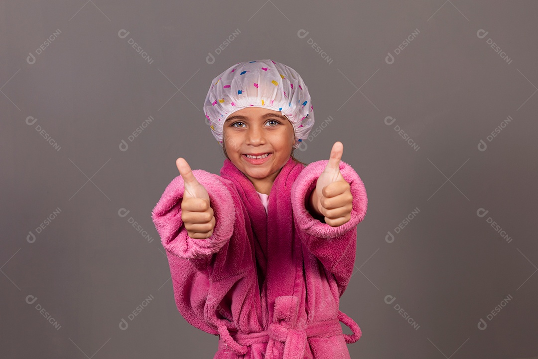 Linda menina usando roupão de banho rosa touca sobre fundo isolado