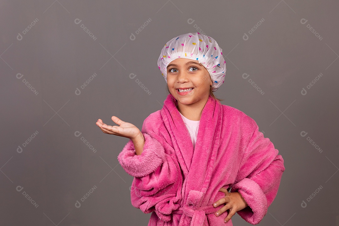 Linda menina usando roupão de banho rosa touca sobre fundo isolado