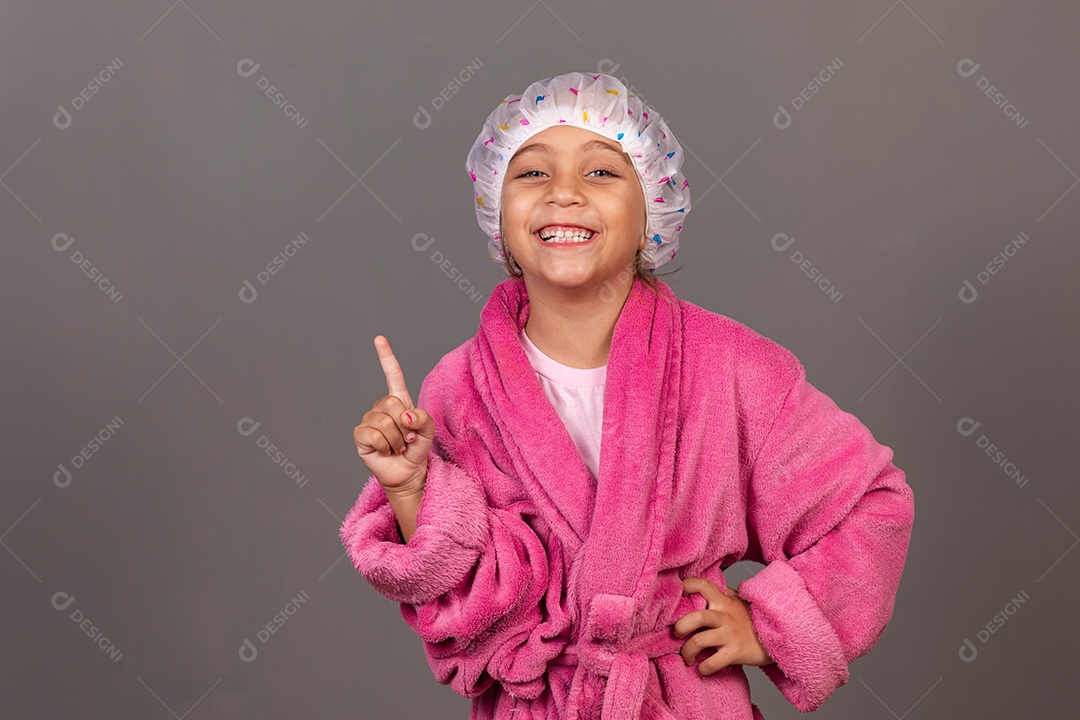 Linda menina usando roupão de banho rosa touca sobre fundo isolado