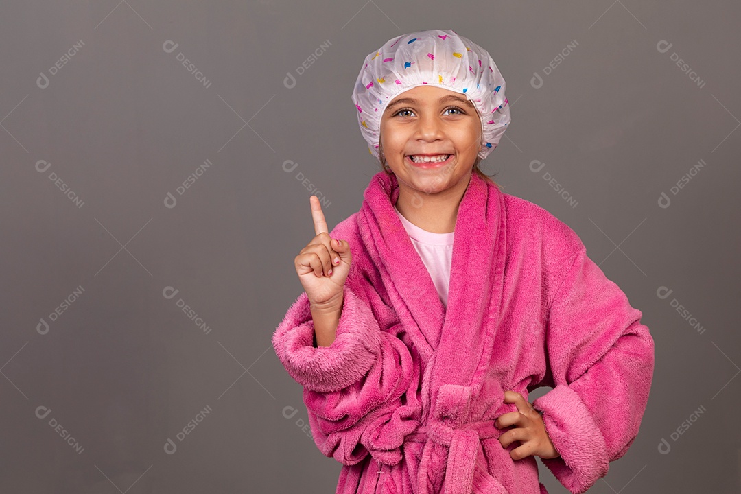 Linda menina usando roupão de banho rosa touca sobre fundo isolado