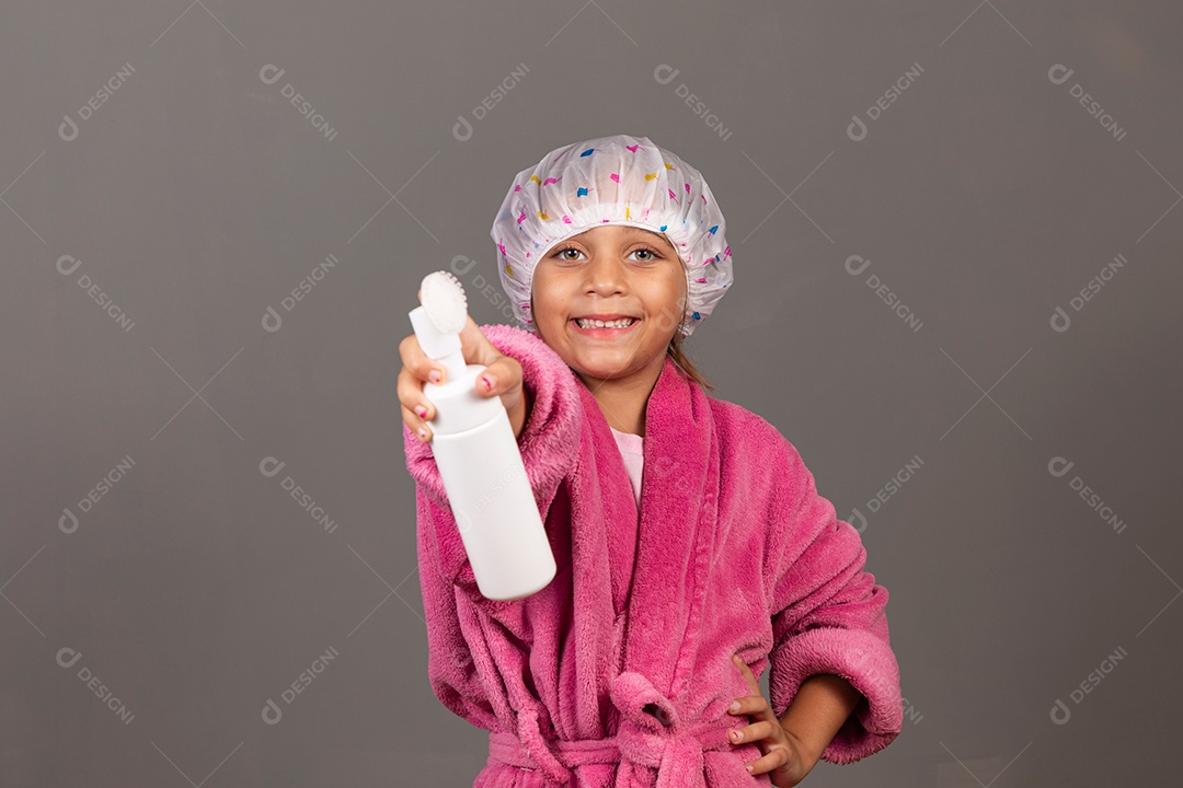 Linda menina usando roupão de banho rosa touca esfoliante sobre fundo isolado
