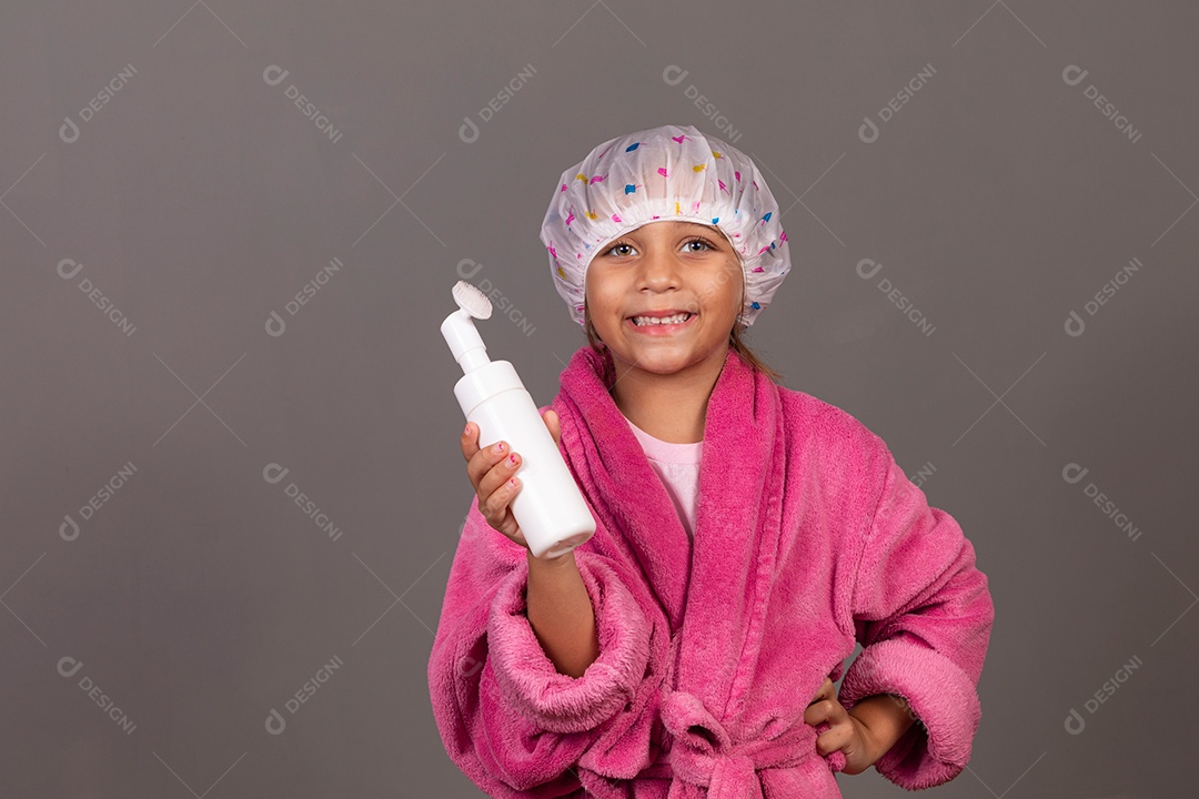 Linda menina usando roupão de banho rosa touca esfoliante sobre fundo isolado