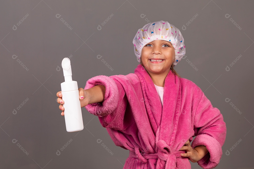 Linda menina usando roupão de banho rosa touca esfoliante sobre fundo isolado